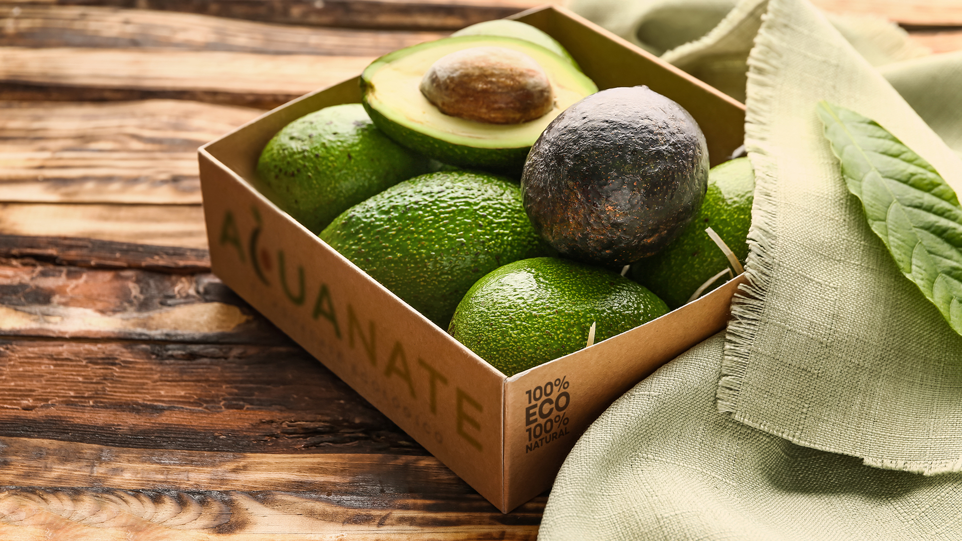 Box with fresh avocado on wooden background